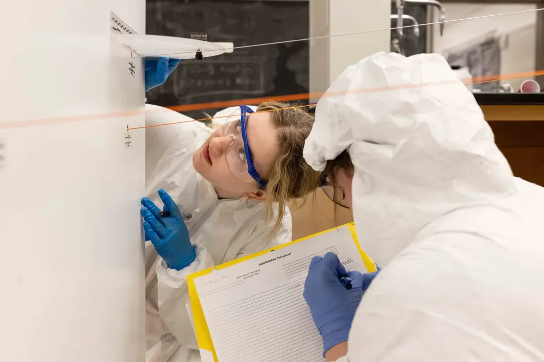 Two students working on a mock crime scene investigation.